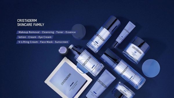 Cristaderm skincare products arranged on a dark blue surface.