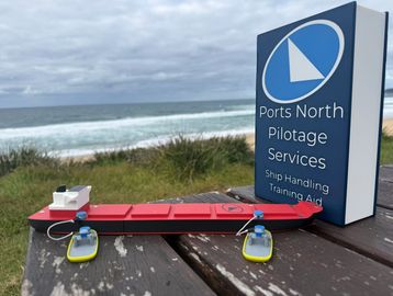 Model boat on a table near the coast with a Ports North sign.