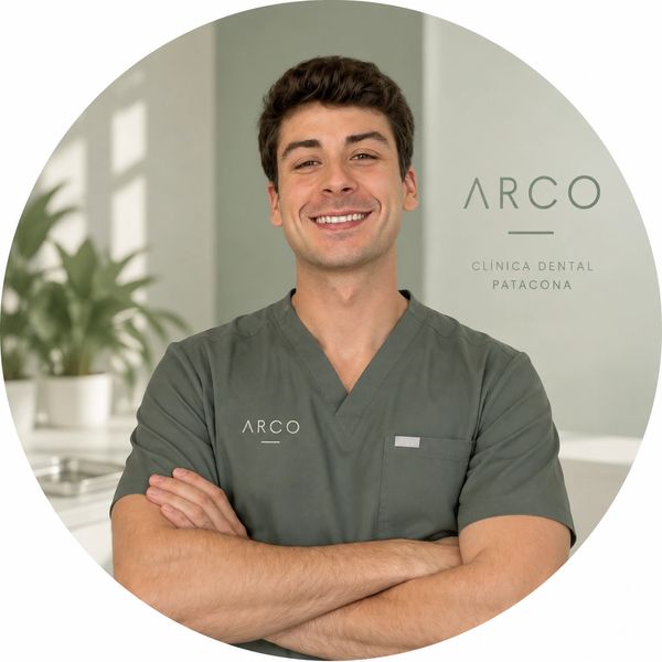 Hombre sonriente con uniforme médico en clínica dental.