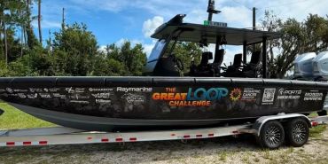 A fishing boat covered in sponsor logos.
