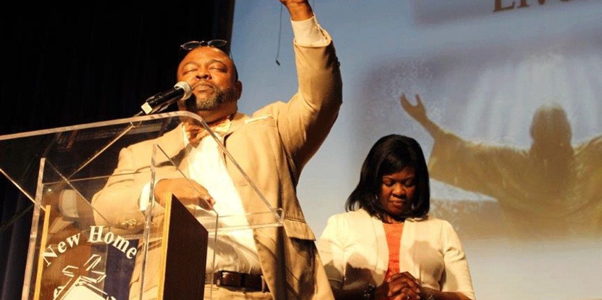 Man and woman praying on stage at a church event.