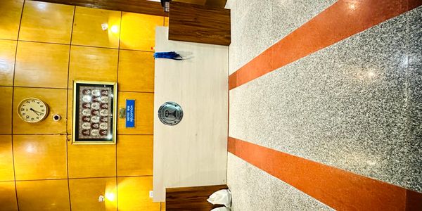Reception area with wooden paneling, clock, and umbrella stand.