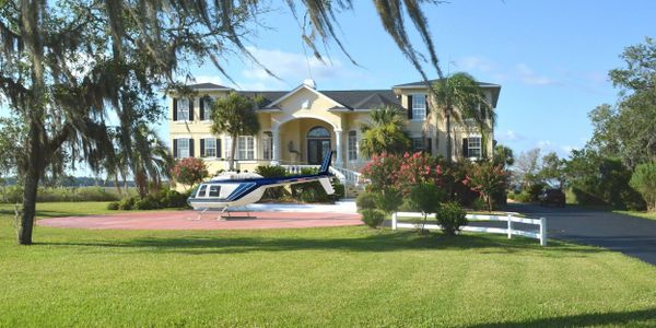 Front of home with helicopter parked out front