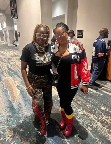 Two women posing indoors with smiles.