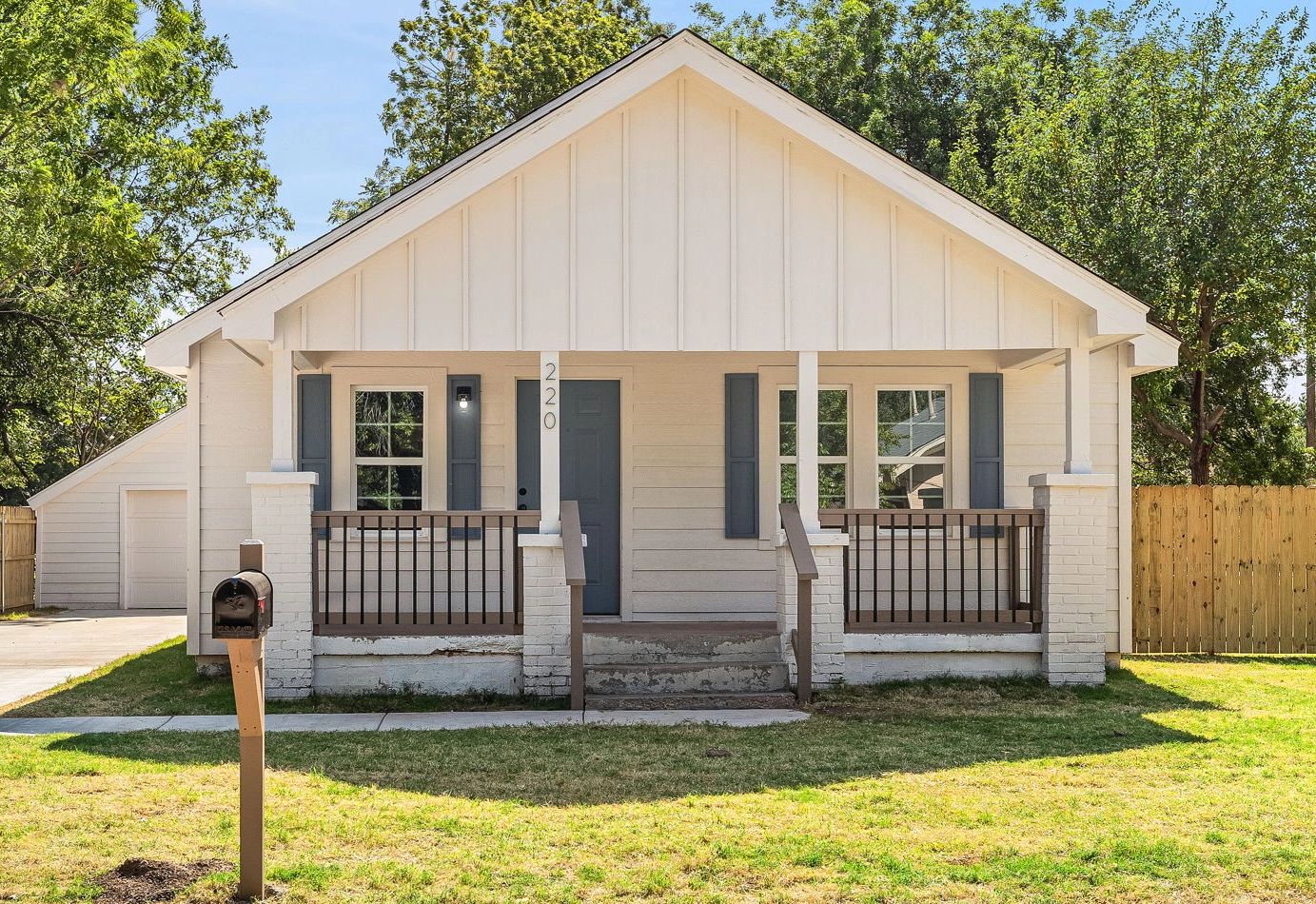 Small white house with front porch and mailbox.