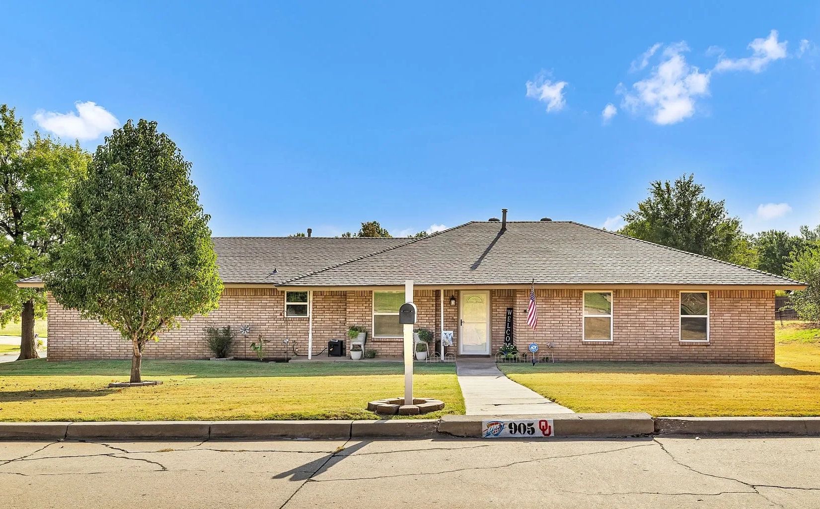 Single-story brick house with a well-kept lawn and mailbox.