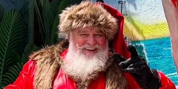 Smiling Santa Claus in red fur-lined coat and hat.