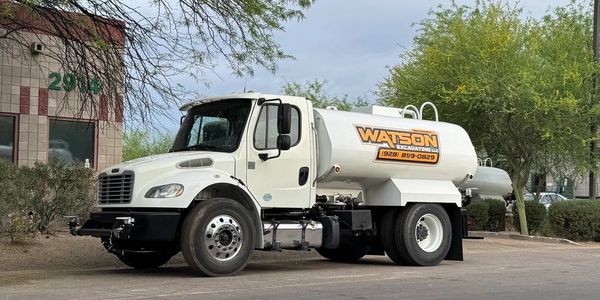A white truck with a yellow and black logo.