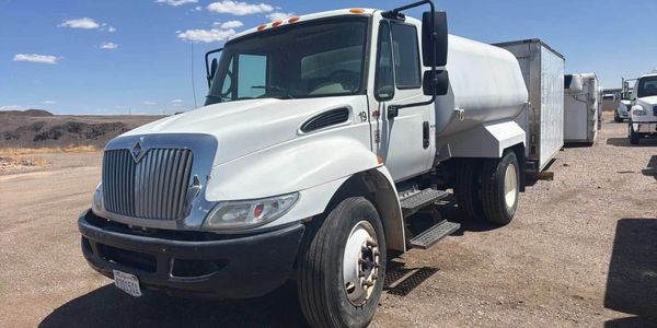 A white truck is parked on the side of the road.