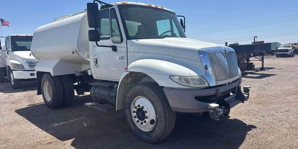 A white truck parked on the side of road.