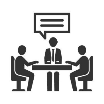 Three people having a meeting or discussion at a table.