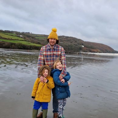 Man on the beach with two children 