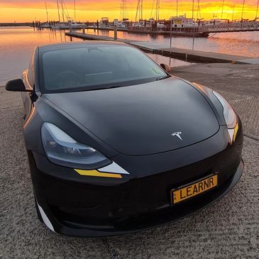 Training vehicle showing business name with a sunset in background.