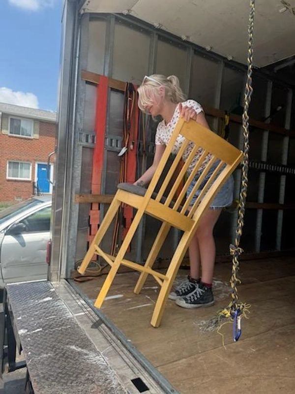 Volunteer lifting a chair.