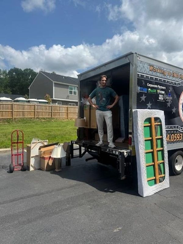 Volunteer with moving truck and furniture.