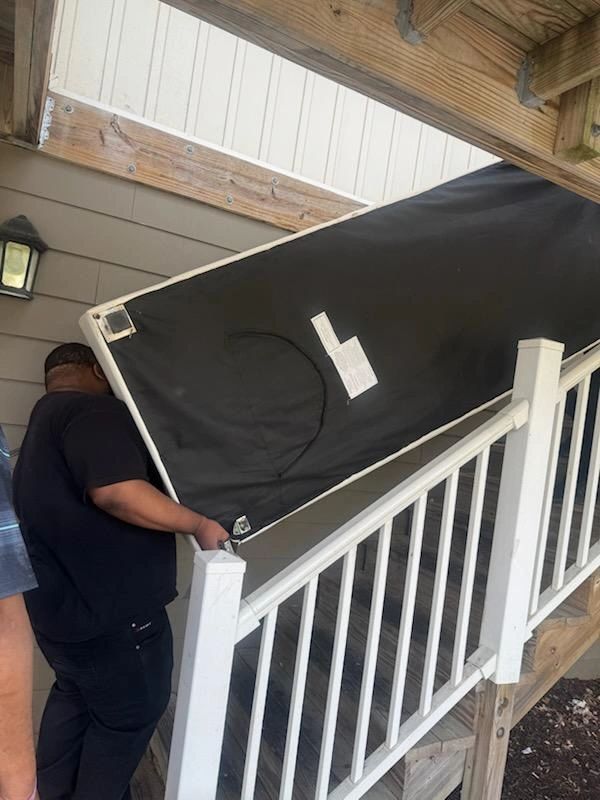 Volunteers carrying mattress upstairs.