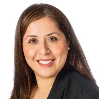 Smiling woman with brown hair in business attire.