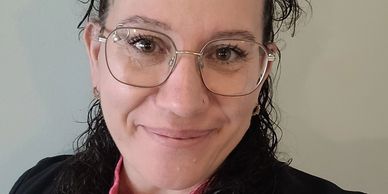 Smiling woman wearing glasses and a black outfit.