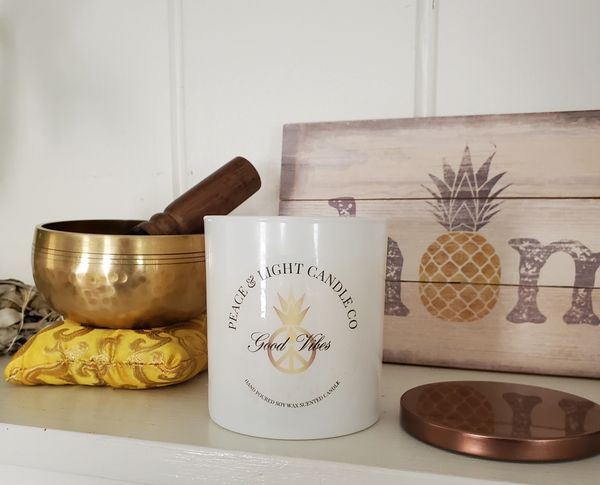 Candle in a white jar with a Tibetan Singing Bowl next to it.