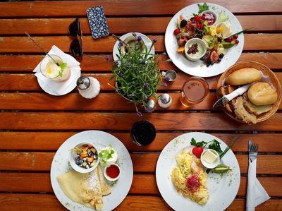 Various plates of food on a brown table top representing food intolerance testing.