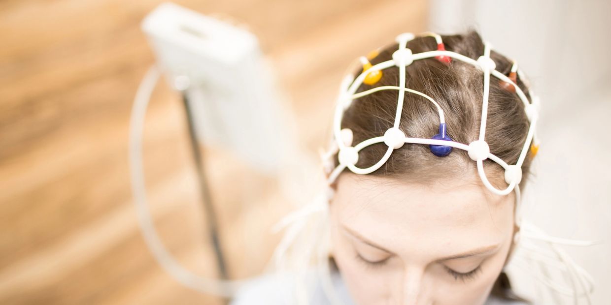 Person wearing EEG cap for brain monitoring.
