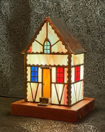 Illuminated miniature house lamp with stained glass windows.