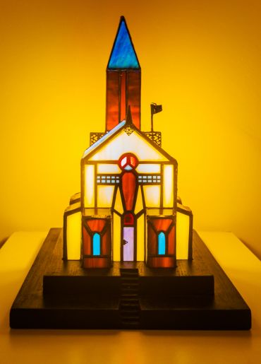Stained glass church model lit up with warm light.