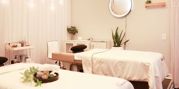 Tranquil spa room with two massage tables and soft lighting.
