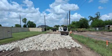 Road construction with heavy machinery under a blue sky.
