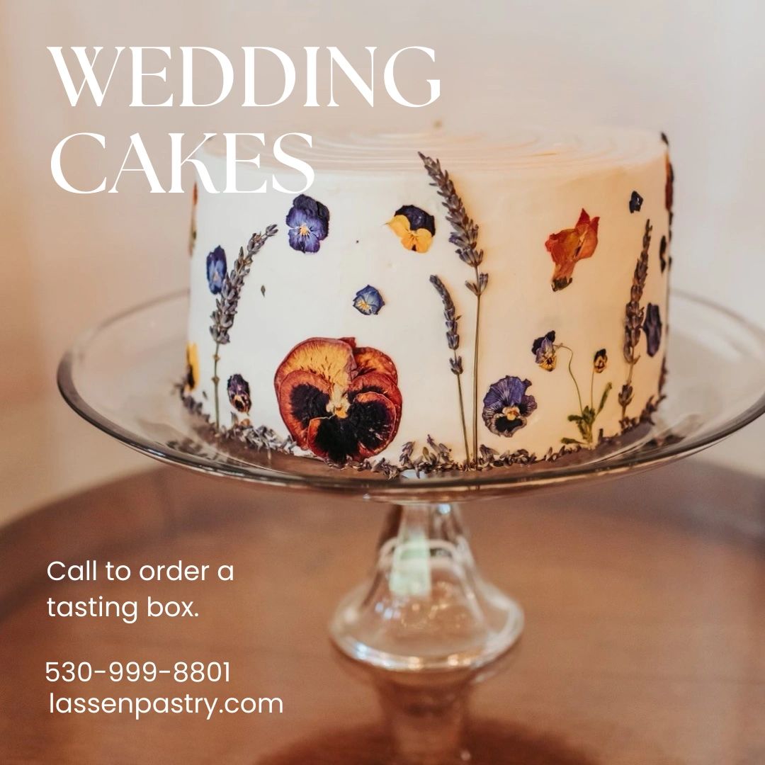 White cake with dried flowers on a glass cake plate. T