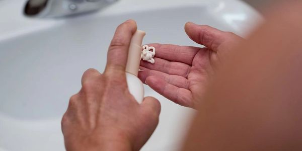 Person pumping lotion out of a container on to their hand
