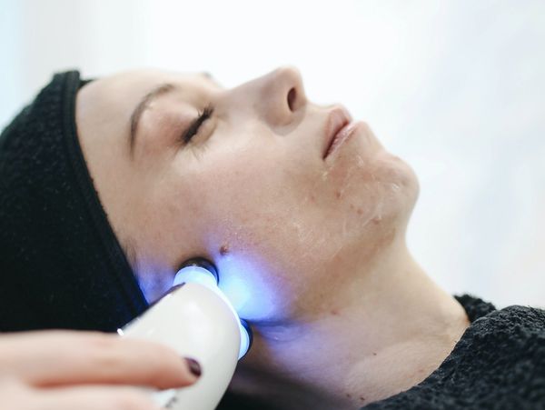 Client receiving a microcurrent treatment during a facial