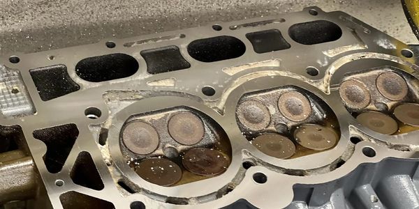 Close-up of a disassembled engine cylinder head showing valves and ports.