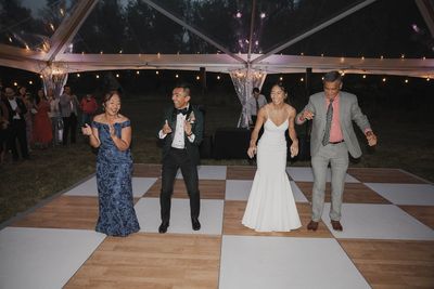 Bride and groom on the dance floor with groom's mom and bride's father.