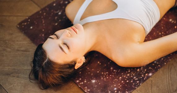 yoga teacher lying down in relaxation pose in meditation