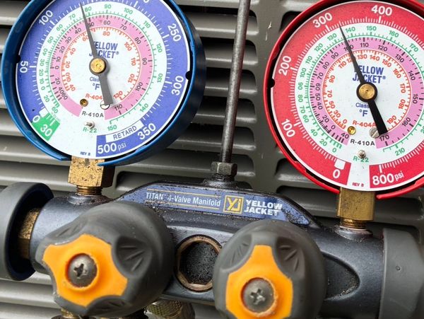 Close-up of Yellow Jacket HVAC pressure gauges with blue and red dials.