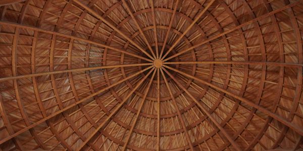 Intricate wooden dome ceiling with radial beams and geometric patterns.