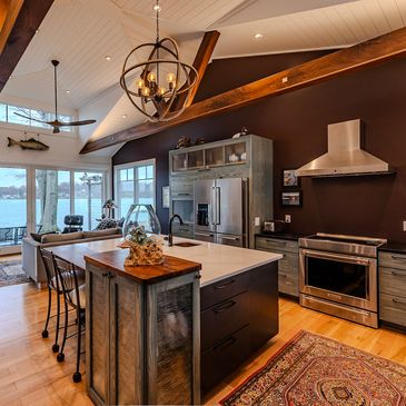Rustic modern kitchen with lake view and wooden beams.