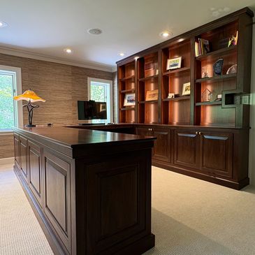 Elegant home office with rich wooden desk and bookshelf.
