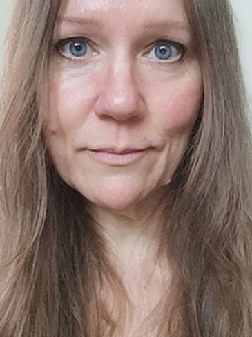Close-up of a woman with long brown hair and blue eyes.