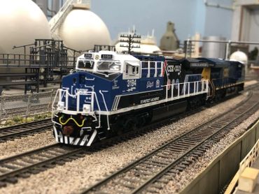 Detailed model train on a miniature railroad track.