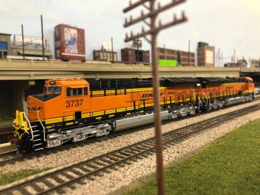 Model train with city backdrop and tracks.