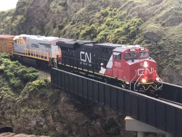 A model CN train crossing a mountain bridge.