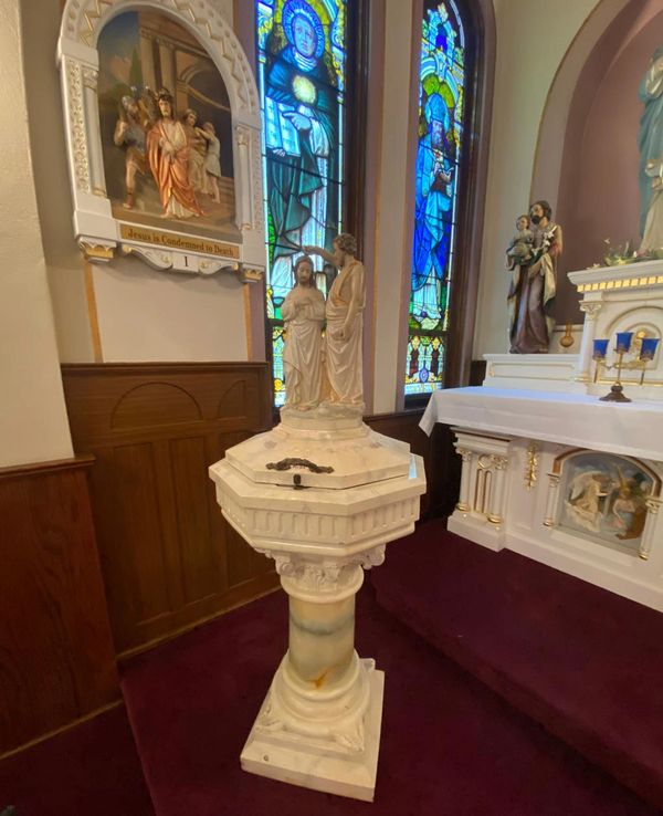 Image inside St. Patrick's Church looking at the baptismal font and Station of the Cross. 