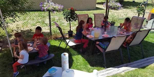 Children enjoying lunch outside on a beautiful day.