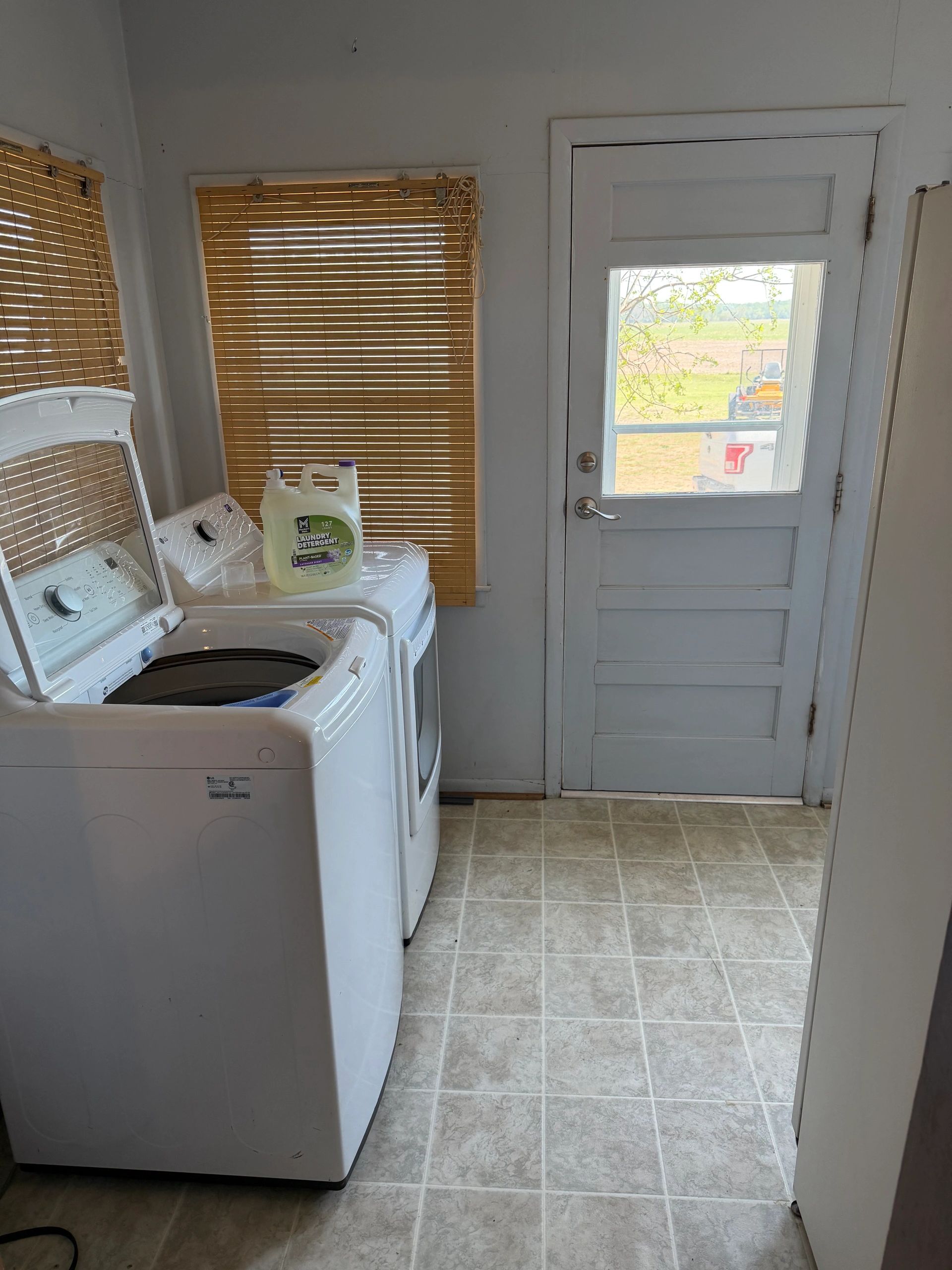 Laundry room with a washer, dryer, and a door leading outside.