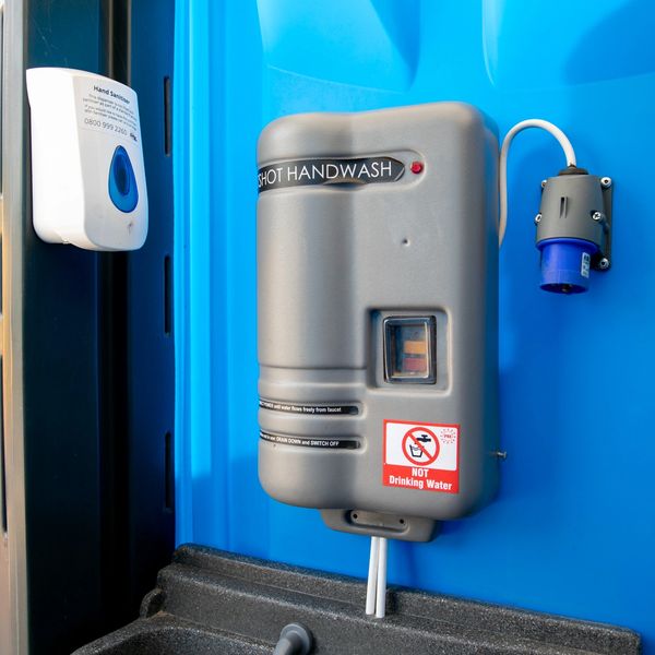 Hot water hand washing facility for portable toilets