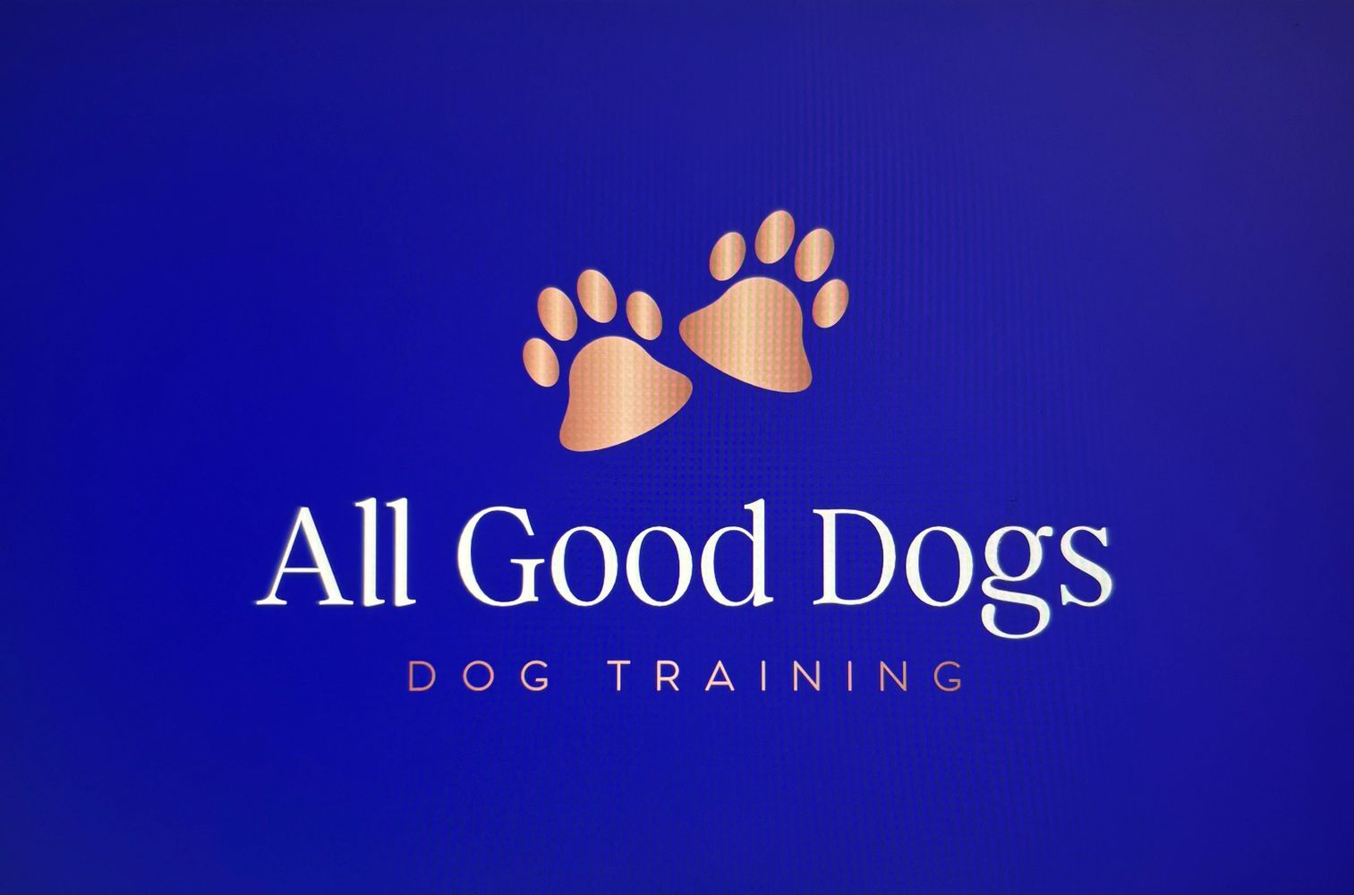 Logo for All Good Dogs, a dog training service with paw prints.