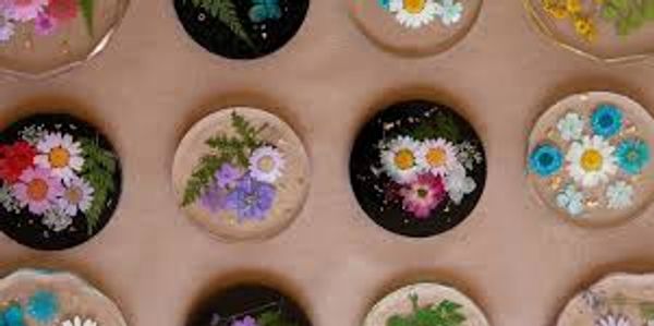 Decorative resin coasters with embedded colorful flowers arranged on a surface.