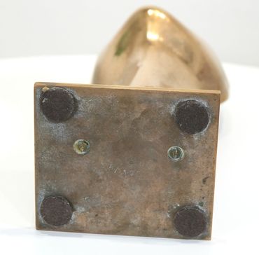 Base of a metallic sculpture with felt pads and screws, numbered 34/100.